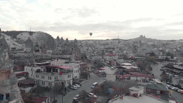 Goreme National park townscape overlooked by hot air ballon at dusk - Fly over Aerial shot