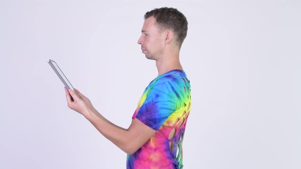 Profile View of Man with Tie-dye Shirt Getting Digital Tablet Taken