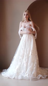 Young Blonde Woman in Elegant White Dress Posein Studio