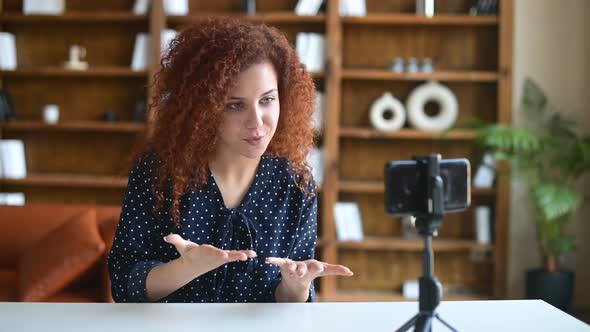 Curly Attractive Woman Speaking to the Camera on the Phone on a Tripod