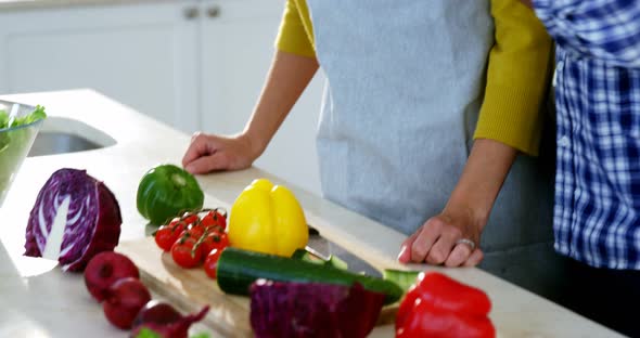 Man feeding woman in the kitchen at home