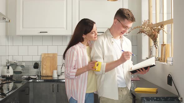 Buisnessman Analizing His Income, While His Wife Looking at the Diary