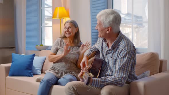 Romantic n Senior Couple Singing and Playing Acoustic Guitar Together