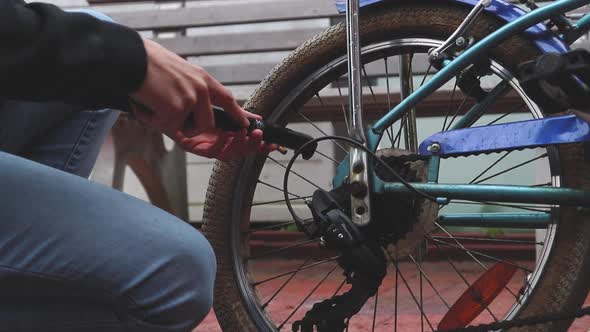 Man inflating the flat tire of the bicycle