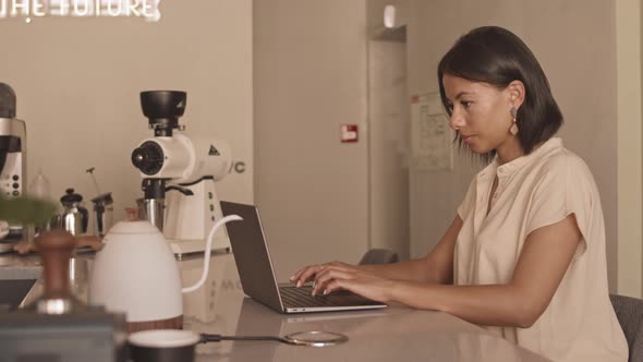 Woman Working Online in Coffee Shop