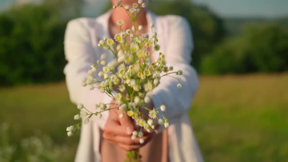 Unrecognizable Female with Wildflowers Outdoors