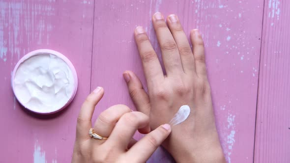 Woman Applying Beauty Cream Onto Skin at Home Top View 