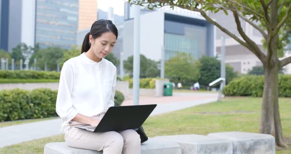 Asian woman use of laptop computer in city