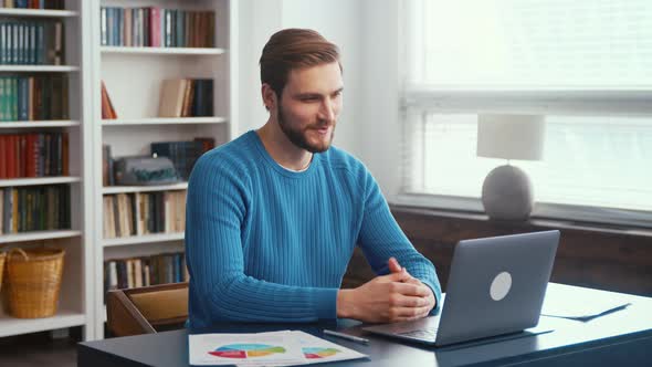 Young male in headphones talk on video call on computer