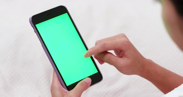 Woman use of mobile phone on bed with chroma key