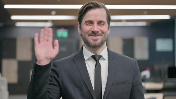 Portrait of Businessman Waving Welcoming