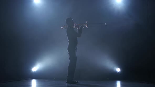 Instrumentalist Plays on a Trumpet Classical Melody. Studio in Smoke
