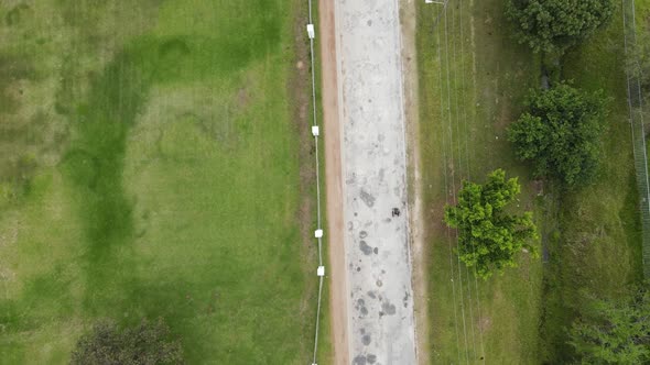 High Angle View of Person in Wheelchair Wheeling Along Road