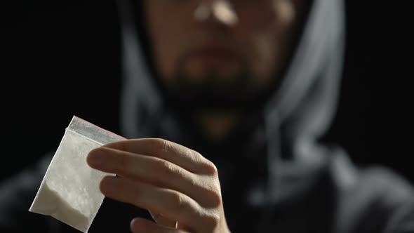 Drug Dealer Holding Cocaine Package in Dark Room, Illegal Deal, Narcotic Crime