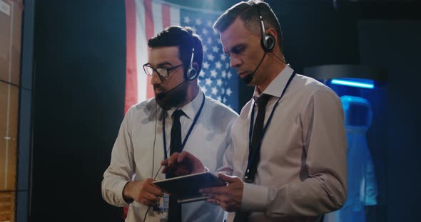 Two Technicians Watching Screen in Control Room