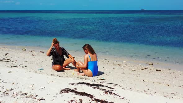 Tourists enjoying life on tranquil resort beach adventure by clear sea with white sandy background o