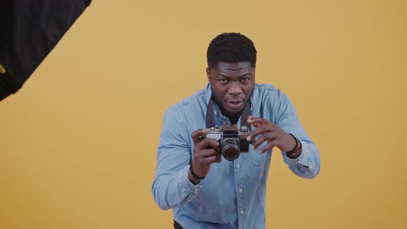 Handsome African American Photographer at Work in Studio Horizontal Video Yellow Background Copy