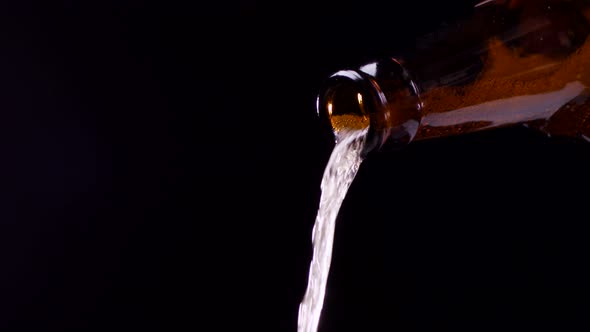 Beer Pouring From Bottle on Black Background