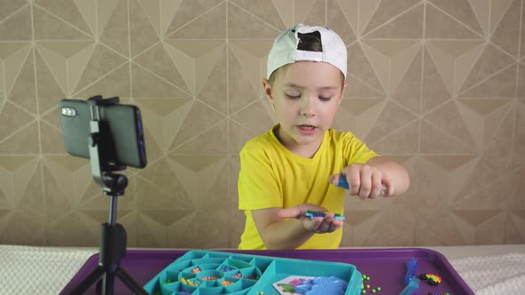 Caucasian Boy Blogger Shows and Tells About the Water Mosaic That Is in the Hands. The Child Records