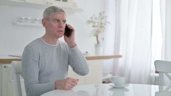 Cheerful Senior Old Man Talking on Smartphone at Home 