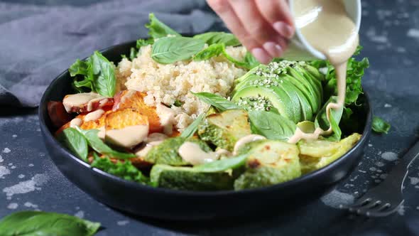 Quinoa salad with baked zucchini, sweet potato, avocado and tahini dressing 