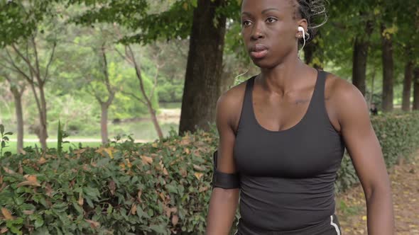 Confident beautiful young athlete walking in the park.Sport,training-slow motion