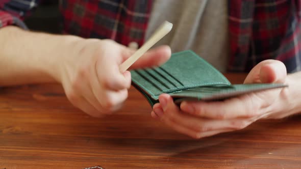 Man Tailor Repairing Wallet Made of Artificial Leather Closeup