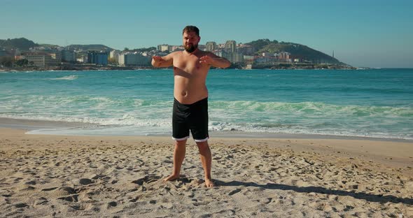 A Man Does Morning Exercises on the Beach