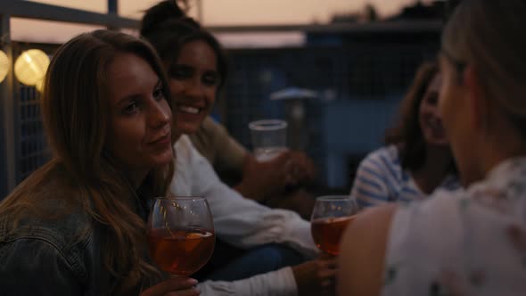 Caucasian girls talking together at evening party in top of the roof. Shot with RED helium camera in