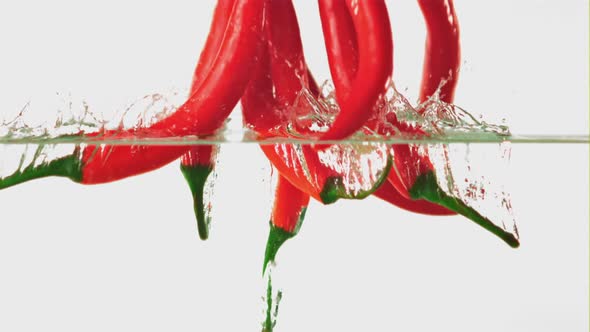 Super Slow Motion Chilli Pepper Falls Under the Water with Air Bubbles