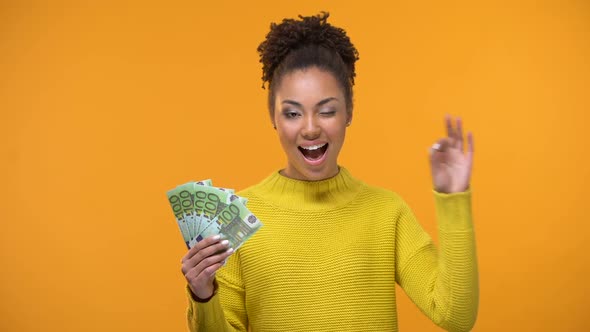 Pretty Black Lady Showing Bunch of Euros and Ok Gesture, Cash-Back Services