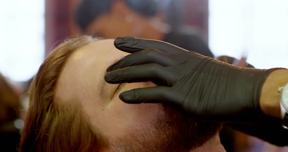 Man getting his beard shaved with razor 