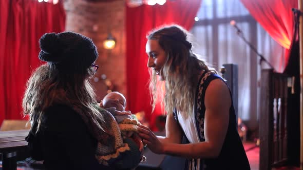 Woman Playing with One Month Old Baby in Bar