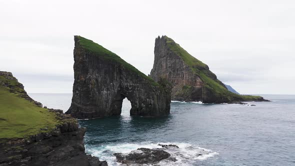 Aerial View of the Rocky Drangarnir Sea Stack in the Faroe Islands and the Skarosafossur Waterfall