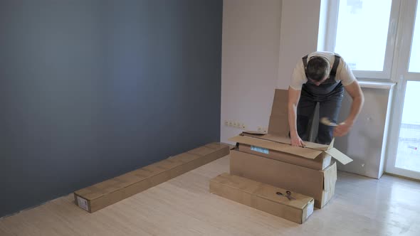 A Worker Unpacks Boxes of Furniture