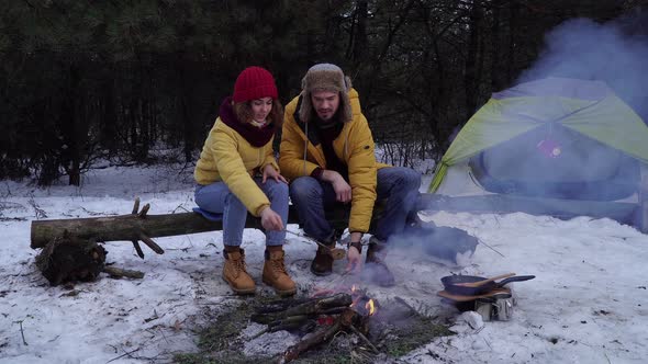 Young Man and Woman on a Picnic in the Winter Forest