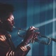 A trumpeter playing in a dark room with rays of light filtering through the shutters - VideoHive Item for Sale