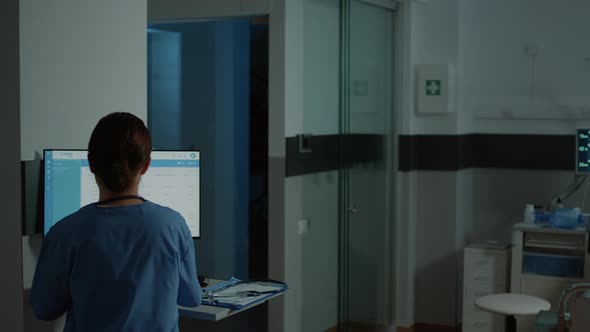 Nurse Examining Medical Results on Computer for Patient