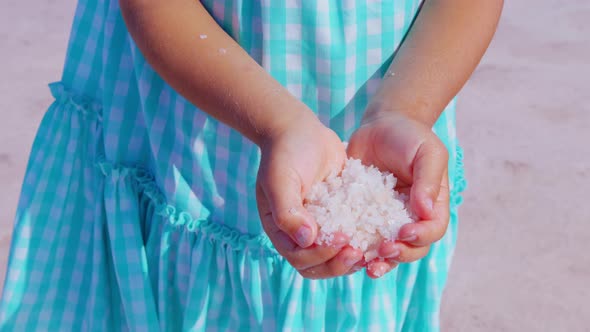 Little Girl Holding Handful of Salt Crystals