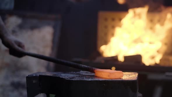 Slow Motion of Blacksmith's Hands with Hammer Struck on the Incandescent Hot Metal on the Anvil the