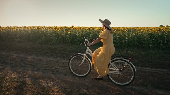 Rural Woman in Timeless Dress Riding Retro Styled White Bicycle on Country Road Alone Near