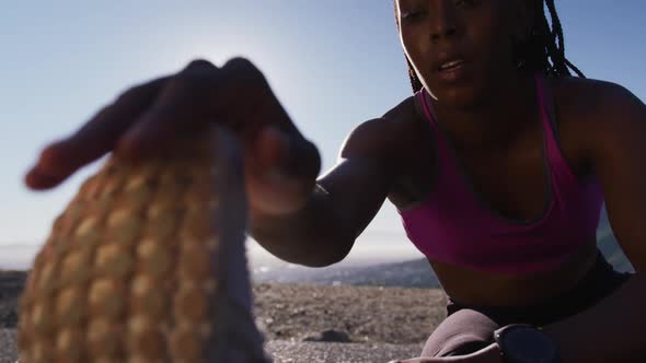 African american woman stretching her legs on the highway