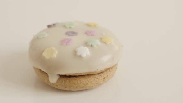 Sprinkles over the glazed cookie in different colors 4K 2160p 30fps UltraHD footage - White teacake 