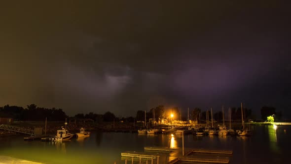 Time lapse of lightning flashing over boat harbor at night