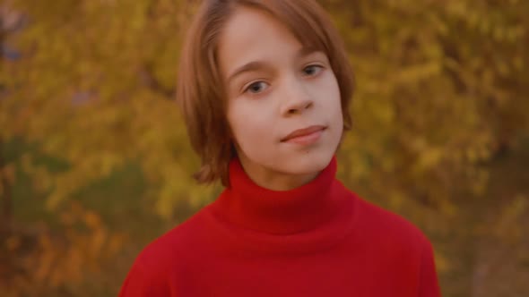 Portrait Handsome Teenager Boy on Yellow Trees Background in Autumn Park. Close Up Happy Young Boy