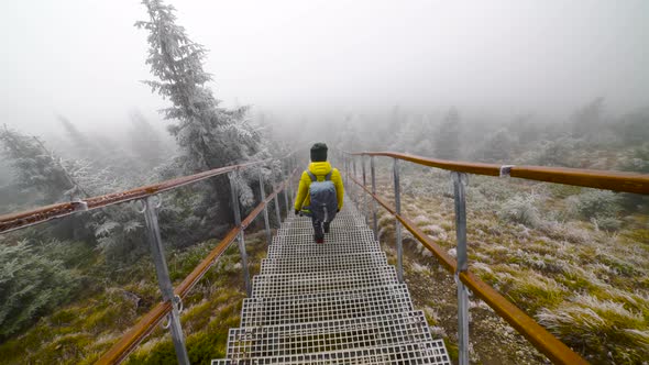 Cinematic Scene of a Person Walking Down the Stairs in the Mountains 