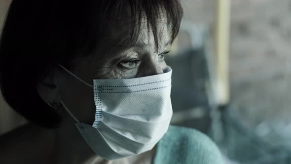 Senior Woman in Face Mask Behind Window on Quarantine