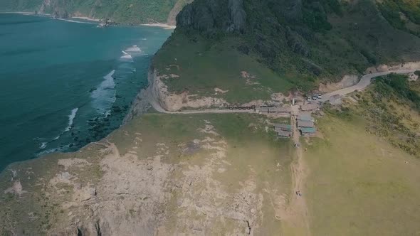 Cinematic aerial drone video of splashing ocean waves into a scenic mountains of Sabtang, Batanes in