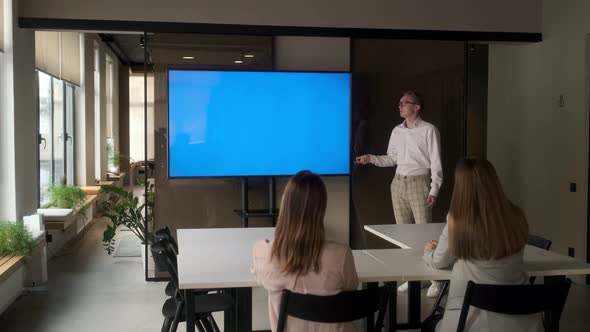 Diverse office conference room meeting male project manager uses Chroma Key wall mounted blue screen