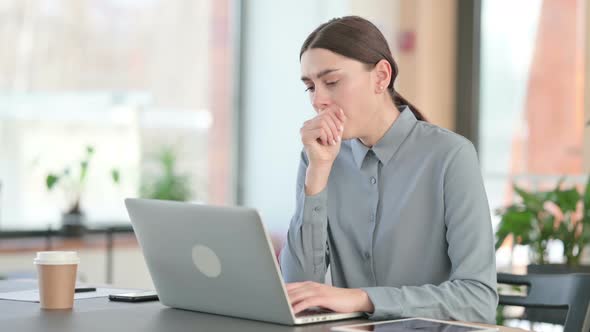 Young Latin Woman Coughing While Using Laptop at Work